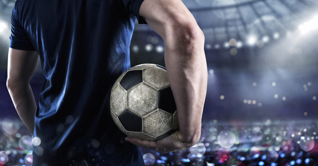 Soccer player ready to play with soccerball at the stadium